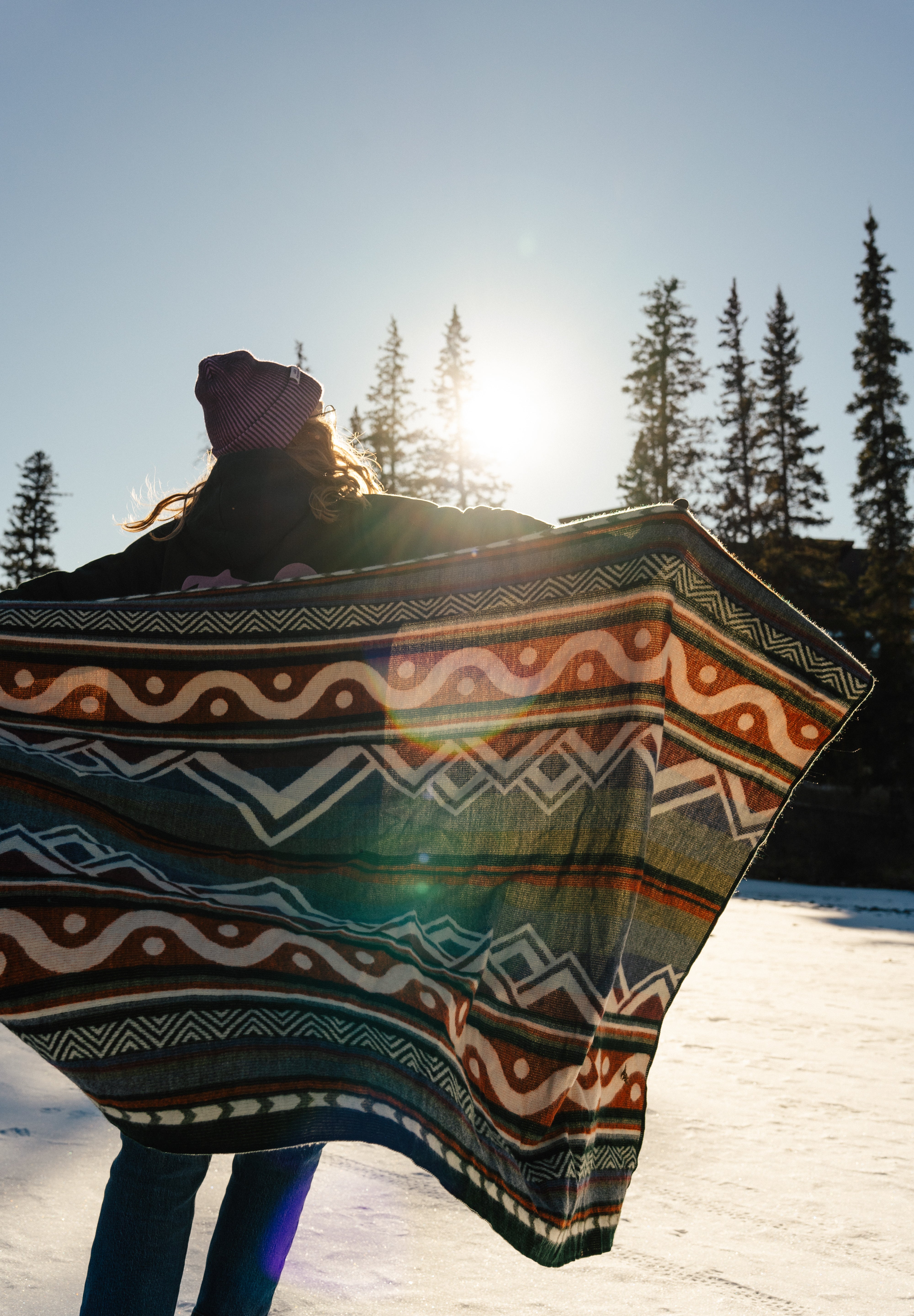 Blanket, shades of blue, orange, lightweight, mountain designs, handcrafted in Ecuador, Acrylic, durable, 70" x 48", soft, camping, van life, outdoors, lifestyle, Les Saisons, Marine Poiraton ski Blanket Mountains orange and green.