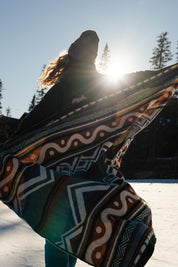 Blanket, shades of blue, orange, lightweight, mountain designs, handcrafted in Ecuador, Acrylic, durable, 70" x 48", soft, camping, van life, outdoors, lifestyle, Les Saisons, Marine Poiraton ski Blanket Mountains orange and green.