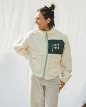 Person wearing a beige jacket  with green accent women