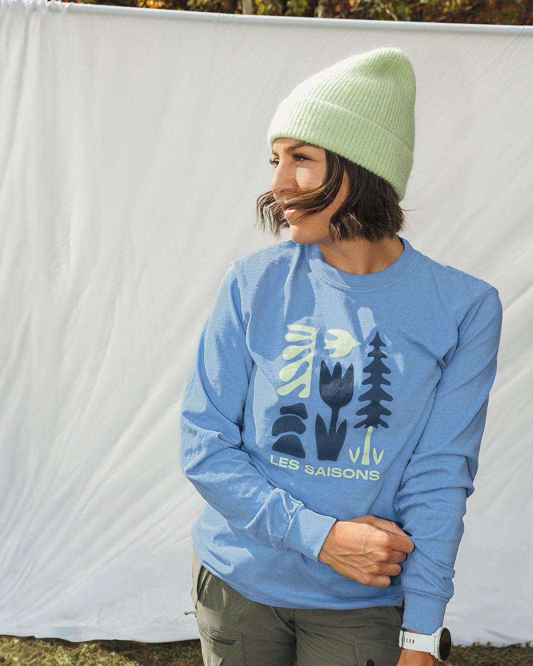 Person wearing a les Saisons blue longsleeve with cute graphic icons printed in the front of the shirt