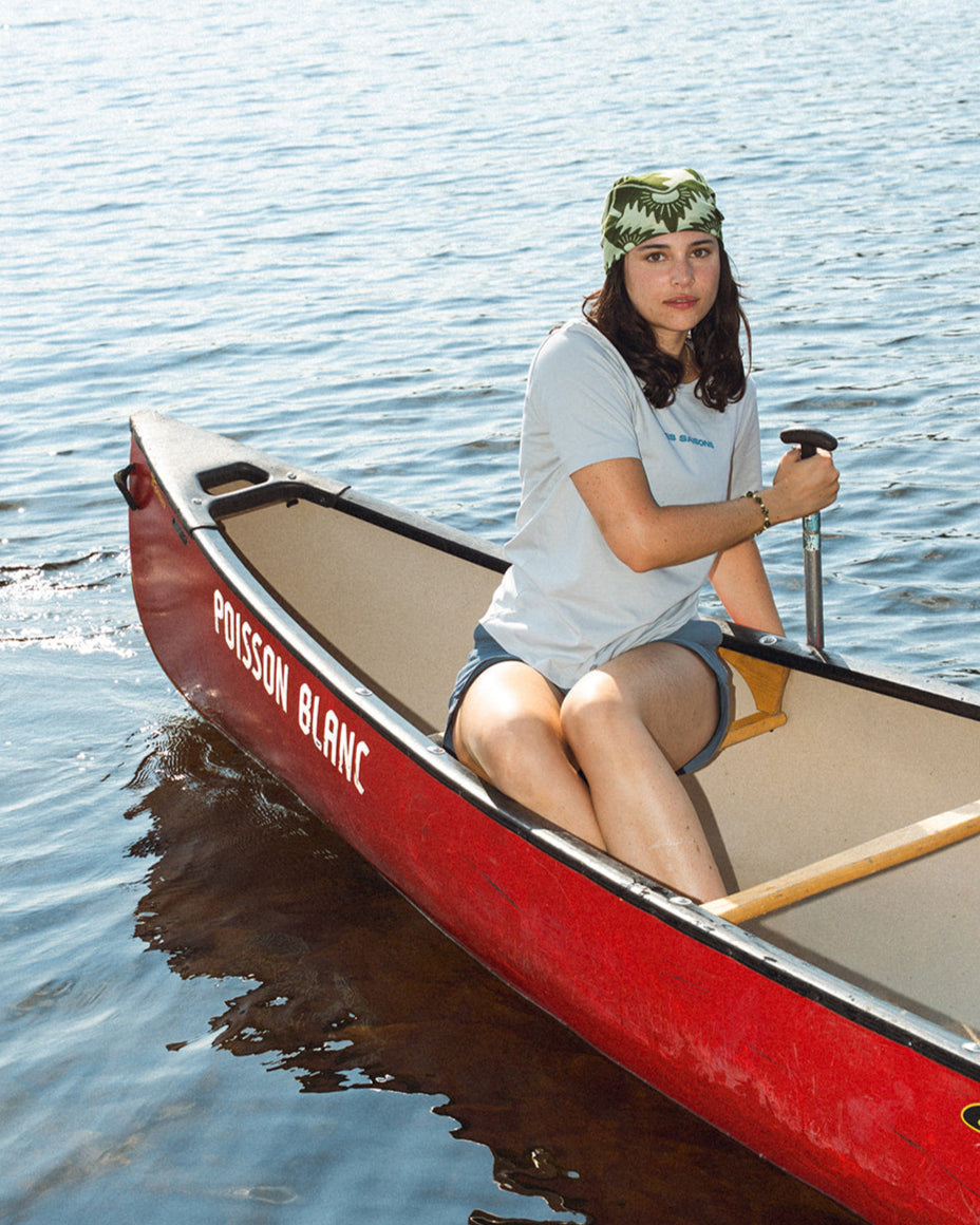 Women sitting in a red canoe on calm water wearing a Grey t-shirt les Saisons