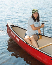 Women sitting in a red canoe on calm water wearing a Grey t-shirt les Saisons
