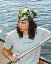 Person rowing a canoe on a body of water wearing a Grey t-shirt with branding.