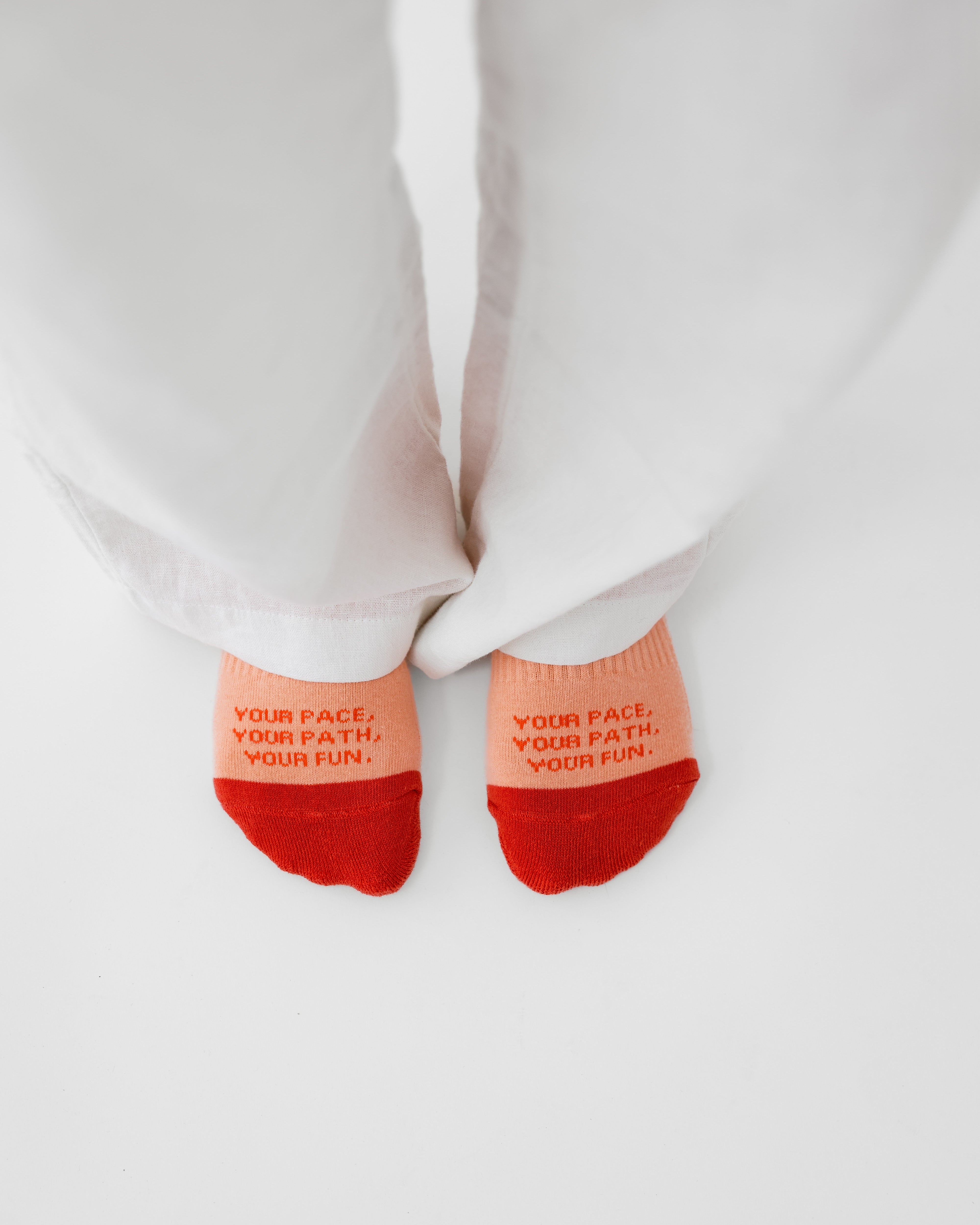 Red socks with text "your pace, your path, your fun" on a white background