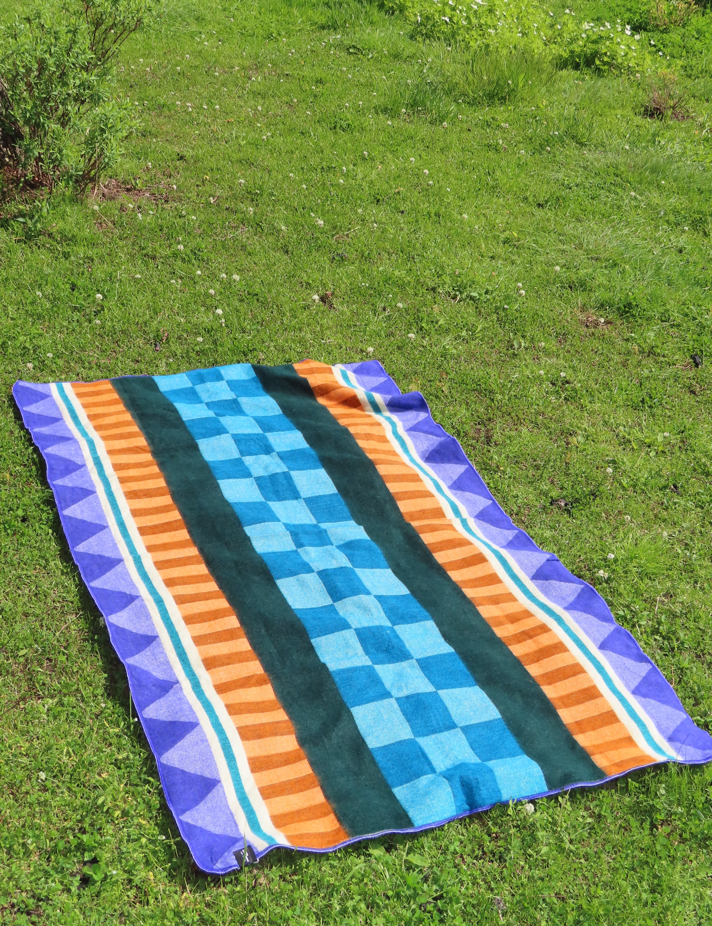 Flat lay of a Geometric Blanket with blue, orange and purple designs