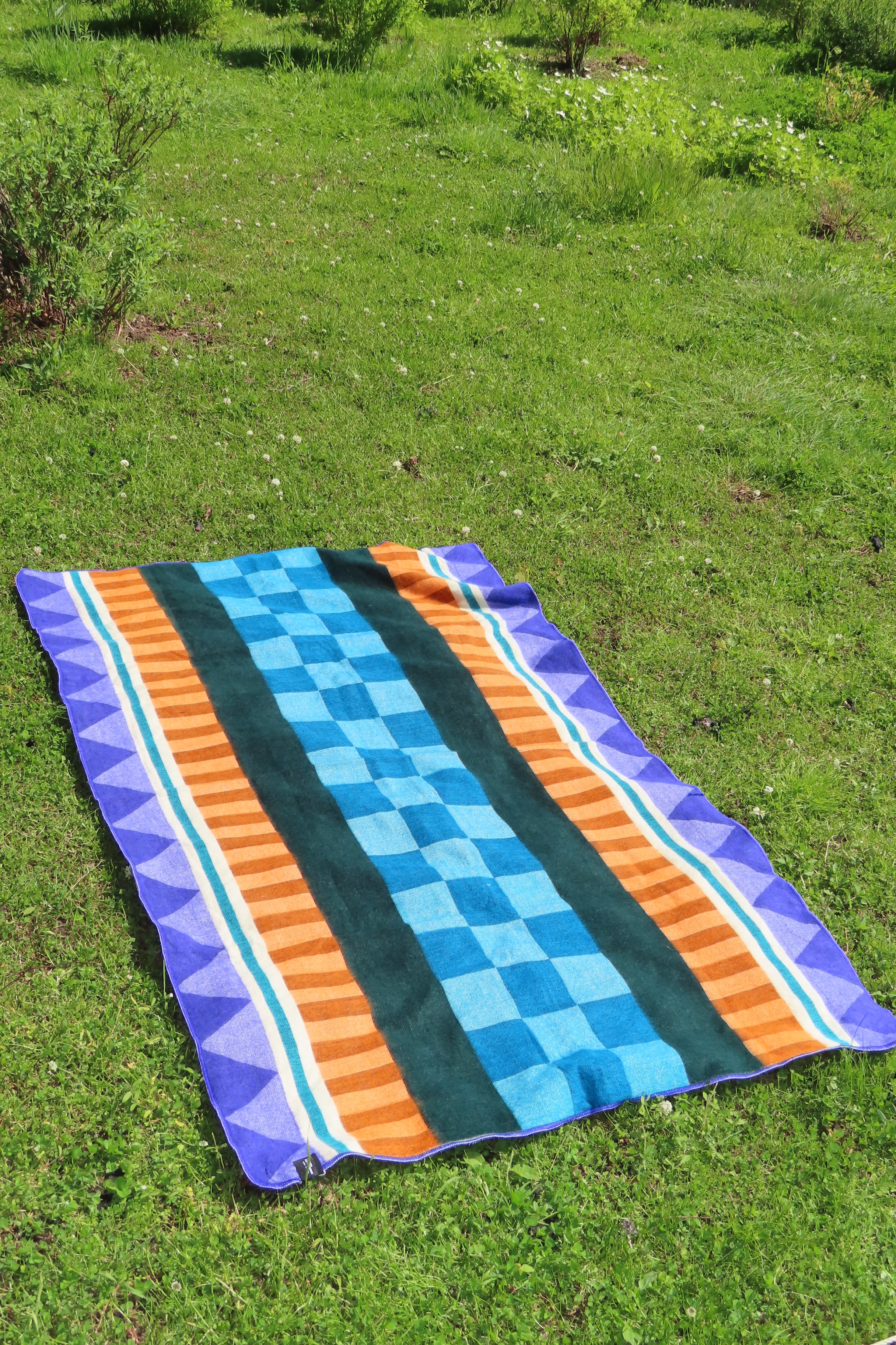 Flat lay of a Geometric Blanket with blue, orange and purple designs