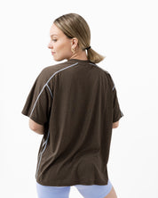 Woman wearing a brown t-shirt with blue lines on a white background