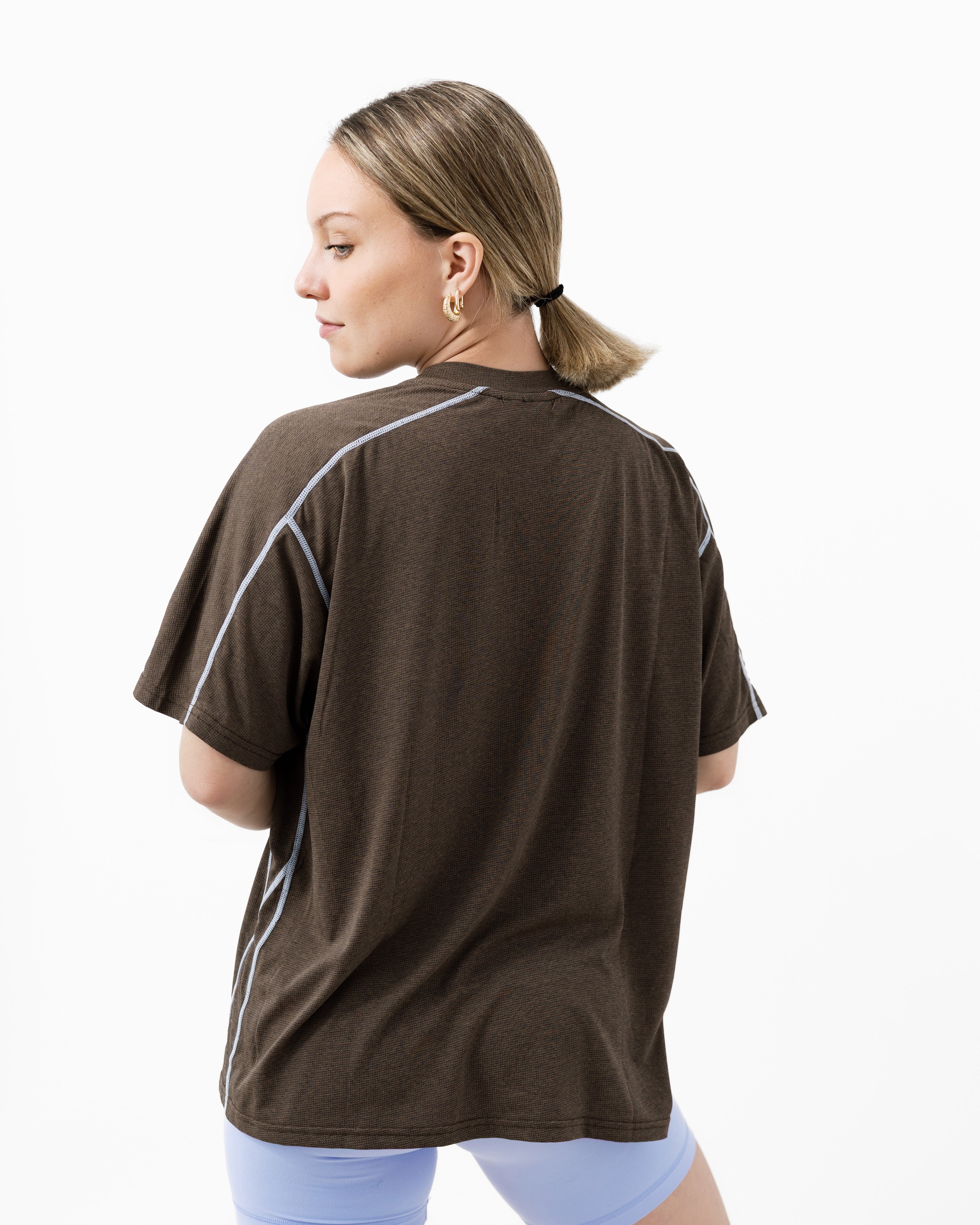 Woman wearing a brown t-shirt with blue lines on a white background