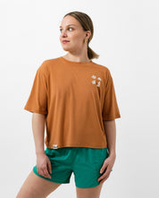 Woman wearing a brown t-shirt and green shorts on a white background