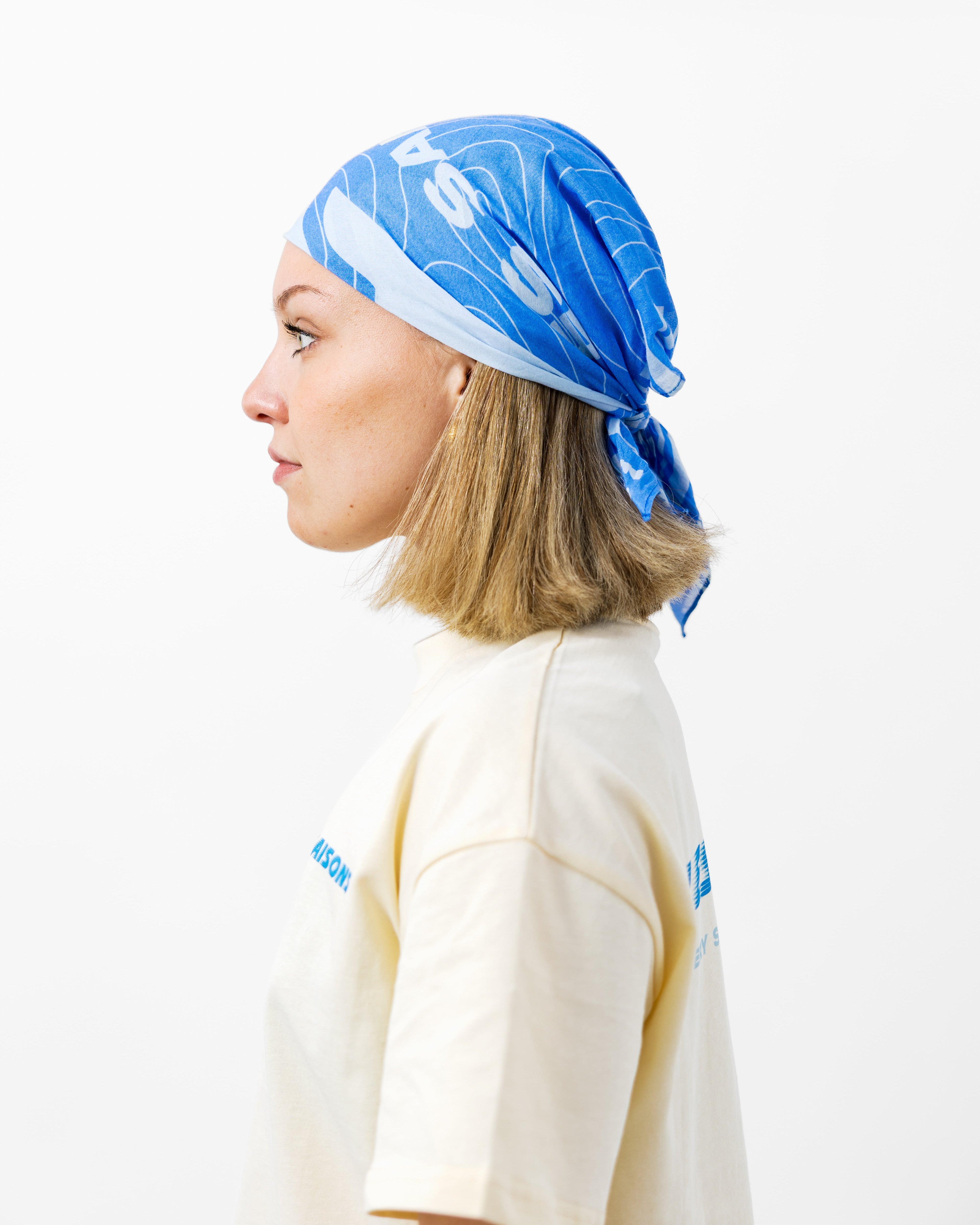 Person wearing a blue bandana with white patterns on a white background