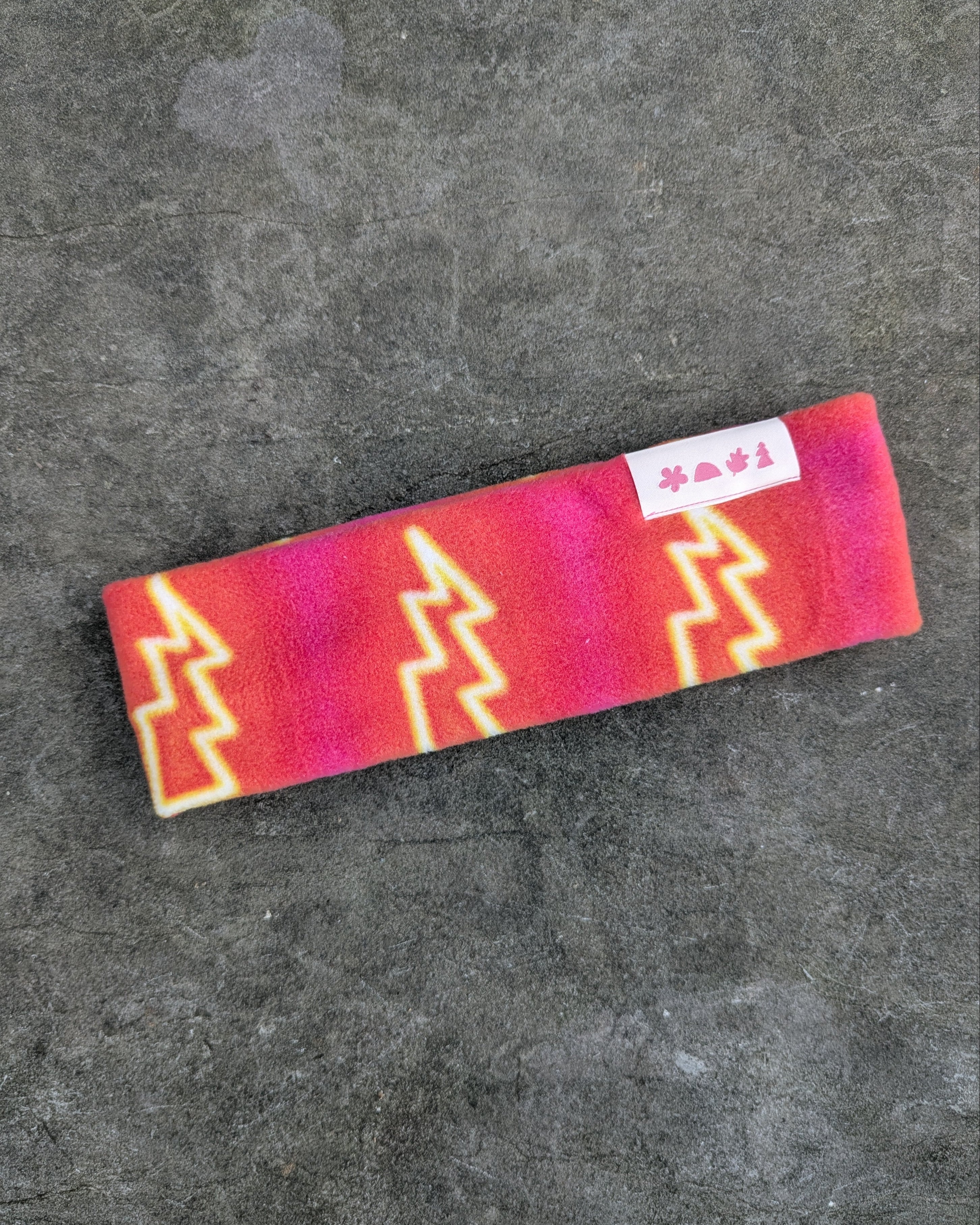 Colorful headband with geometric lightning pattern on a gray surface - les Saisons