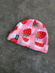 Light pink and white checkered fleece beanie with strawberry pattern