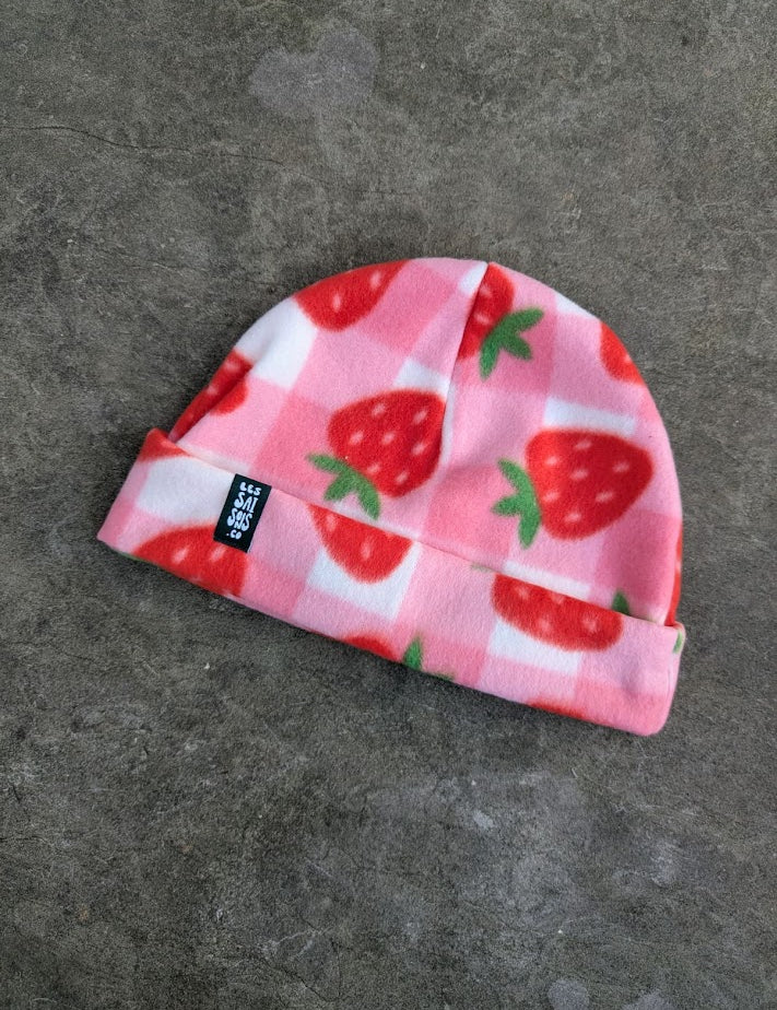 Light pink and white checkered fleece beanie with strawberry pattern