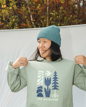 Woman wearing striped blue and back beanie with light green sweater