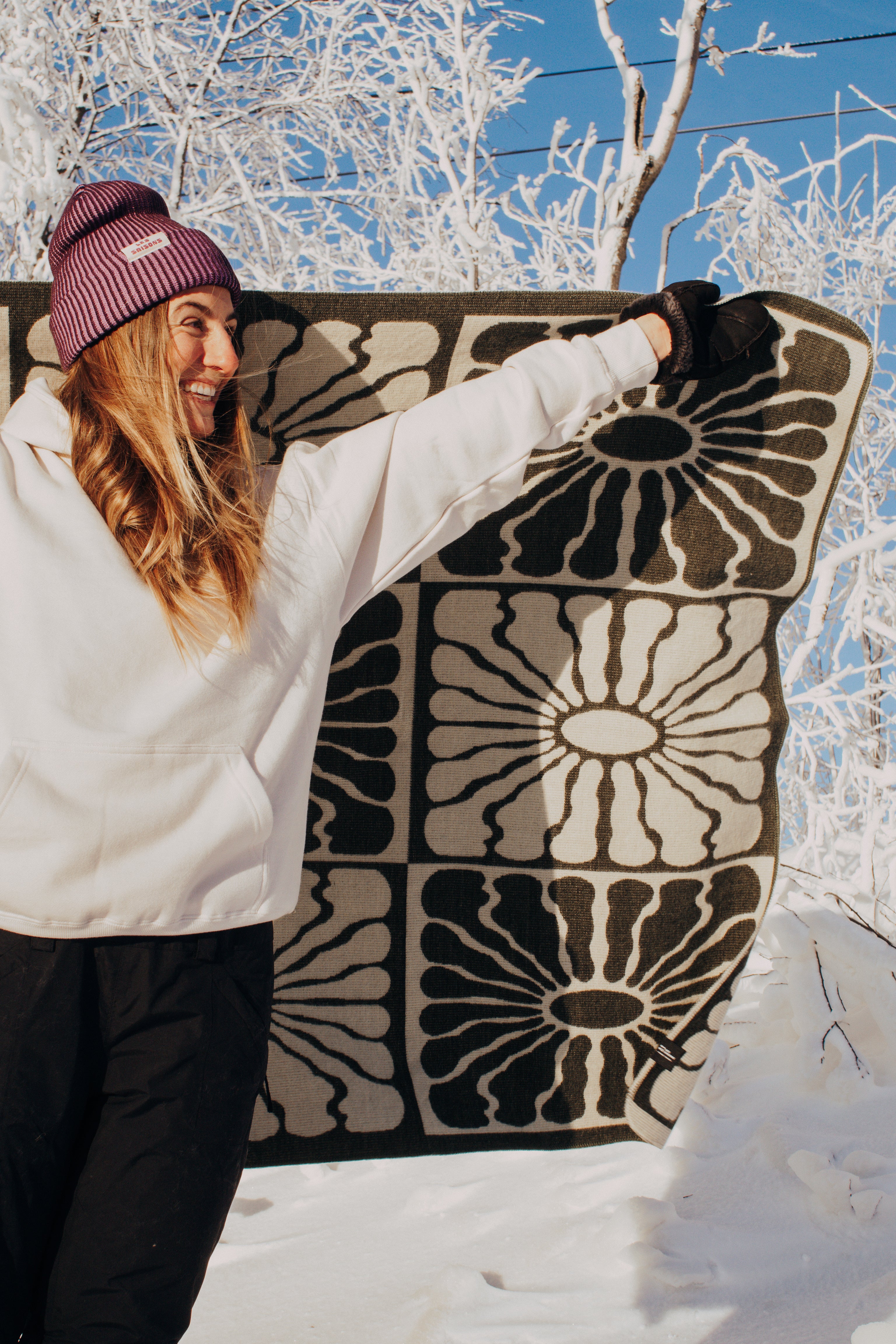 green and white, light weight blanket, sun pattern, camping, van life, outdoors, warm, Les Saisons, Blanket boho, adventure, aesthetic, designer blanket, artist collaboration, acrylique, soft cozy, couverture douce, décor, design intérieur, organic, geometric, artiste, vert et blanc, motif de soleil.