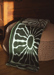 green and white, light weight blanket, sun pattern, camping, van life, outdoors, warm, Les Saisons, Blanket boho, adventure, aesthetic, designer blanket, artist collaboration, acrylique, soft cozy, couverture douce, décor, design intérieur, organic, geometric, artiste, vert et blanc, motif de soleil.
